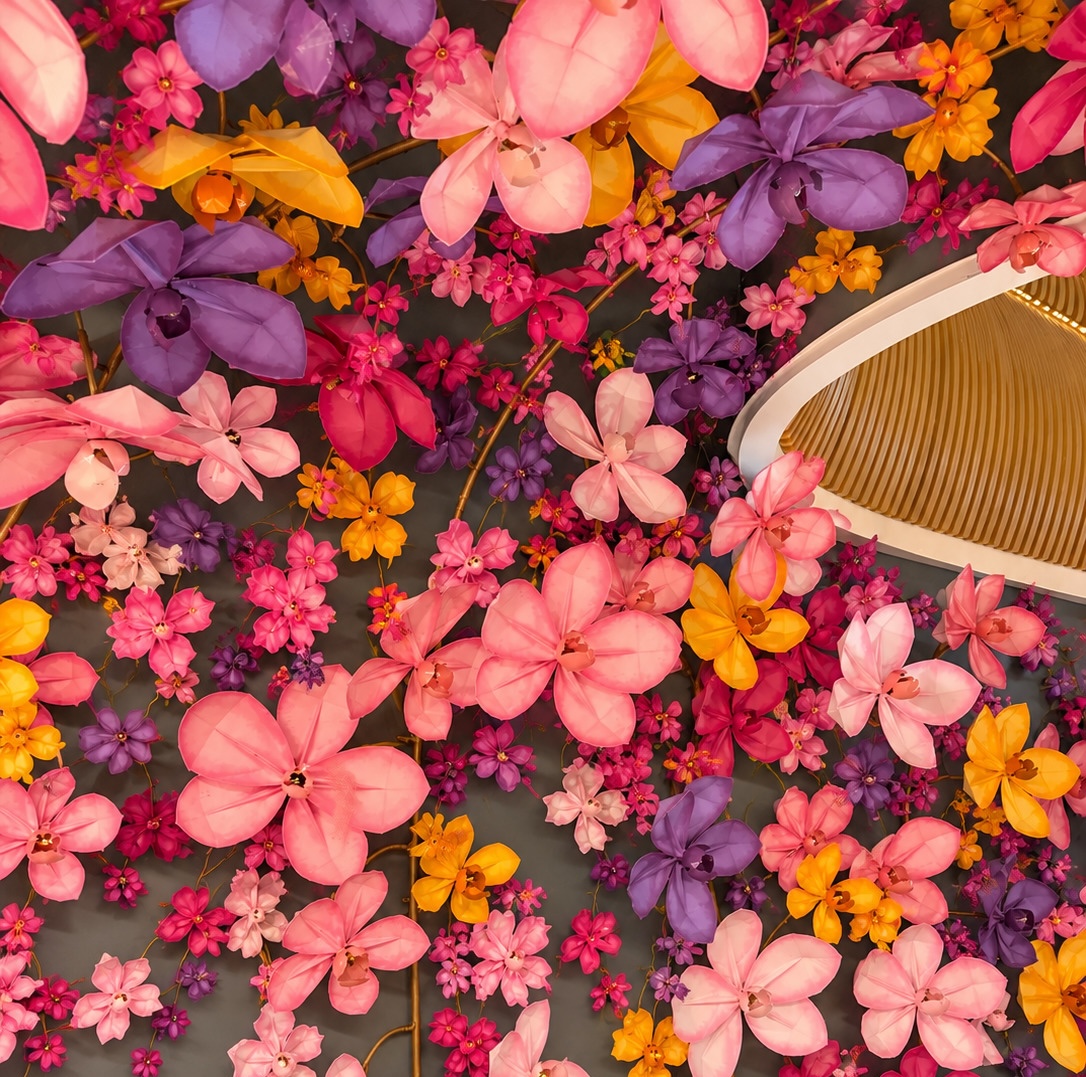 an ornate paper floral ceiling installation with a hanging light fixture