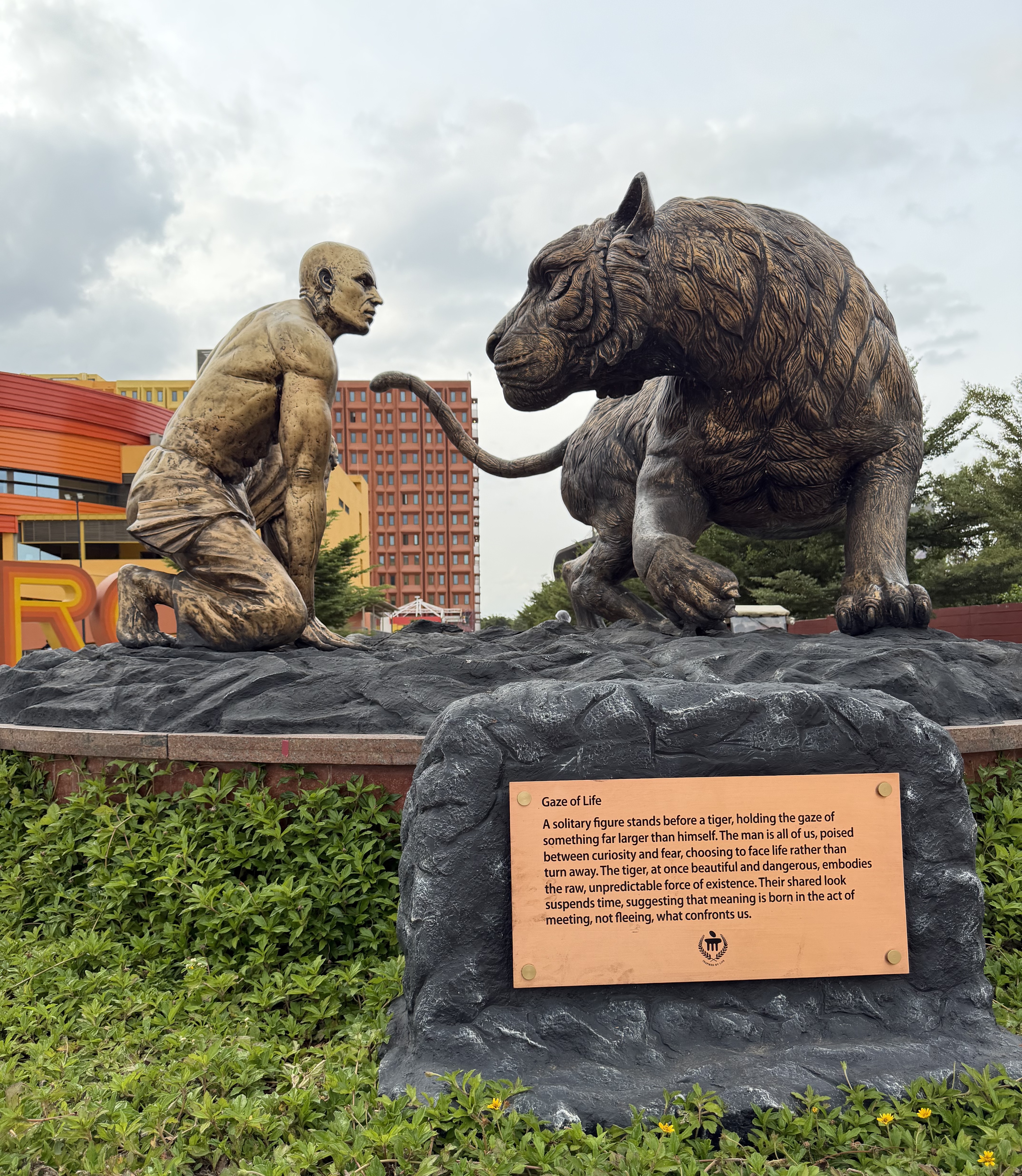 bronze statue titled Gaze of Life, a man kneeling face to face with a tiger